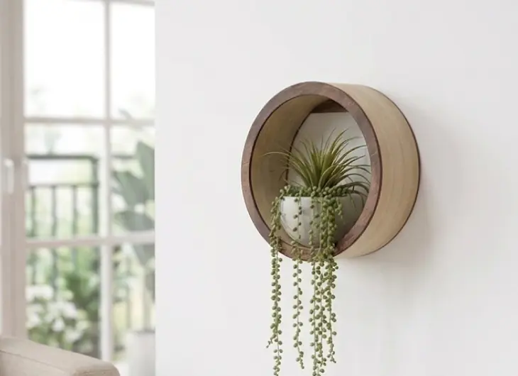 レーザーカッターで制作した円形の木製壁掛け時計。温かみのある桐の板に水平方向のスリットを施したモダンなデザイン。