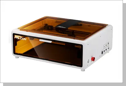 エンクロージャー付きモデルの例。オレンジ色の保護パネルで全体が覆われており、煙や光を遮断できるフルカバータイプのレーザー加工機。